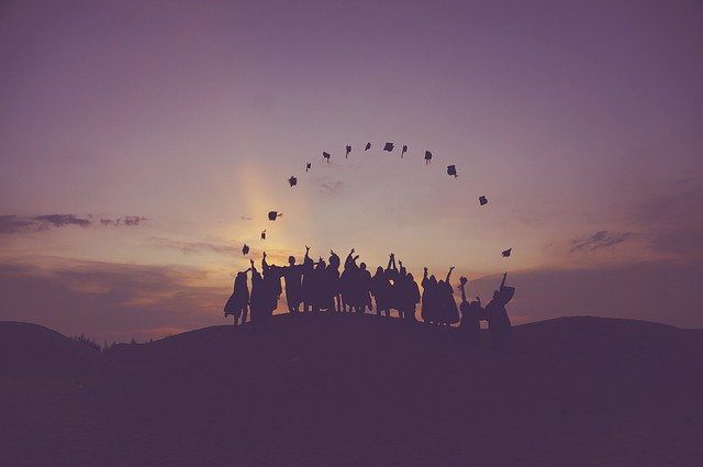 Graduates celebrating at sunset