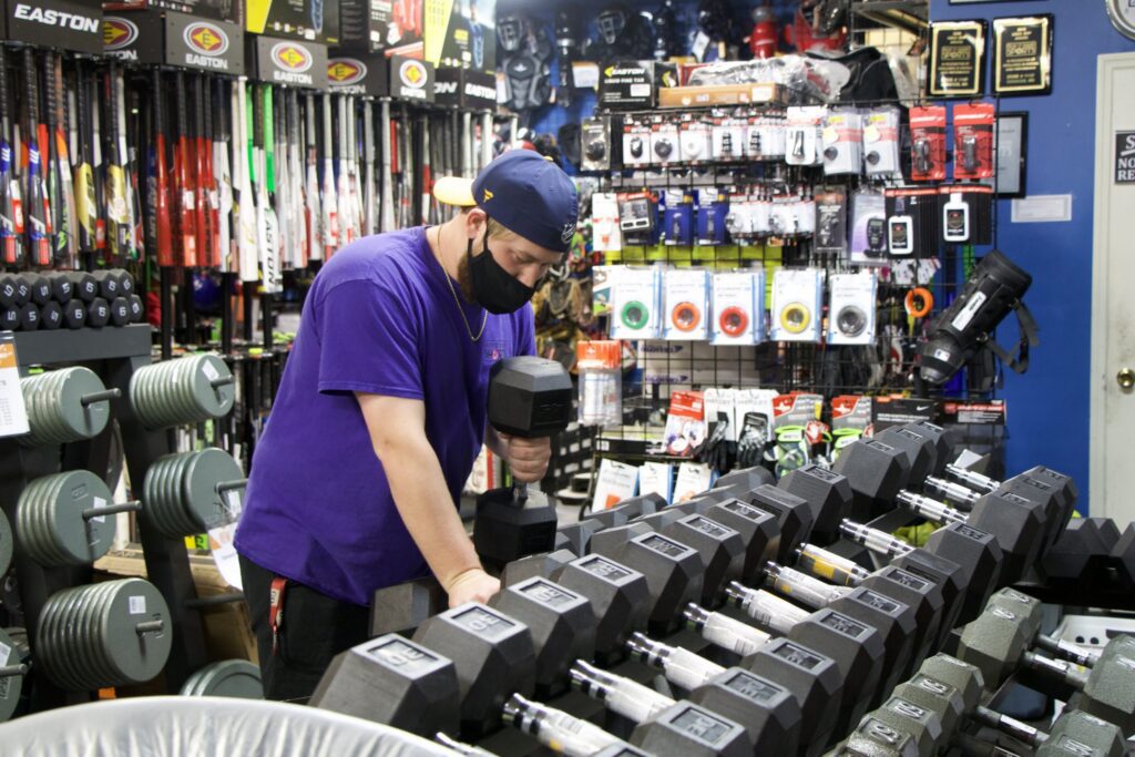 Man selecting dumbbell in sports store