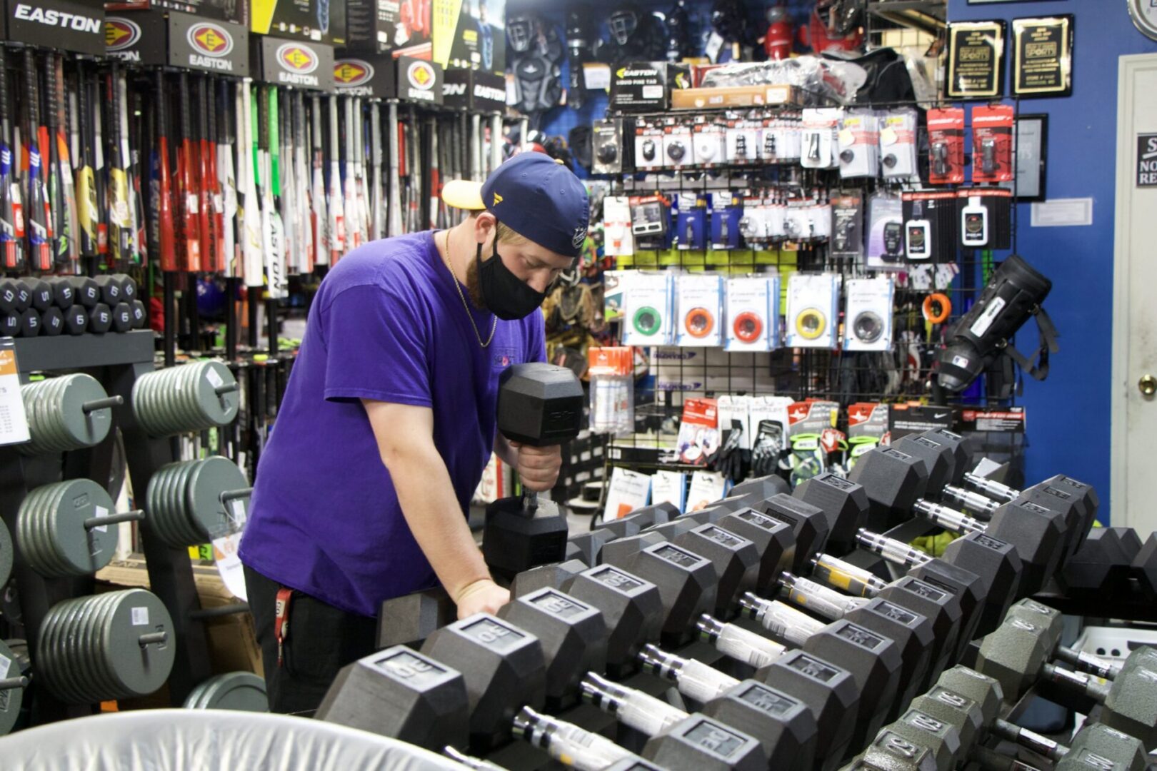 Man selecting dumbbell in sports store