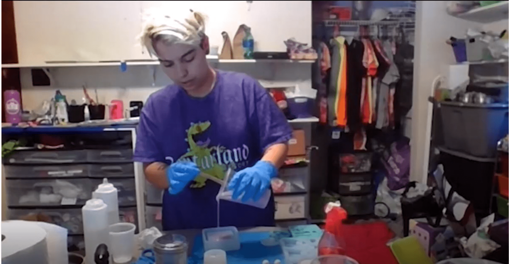 Individual wearing gloves working with containers.