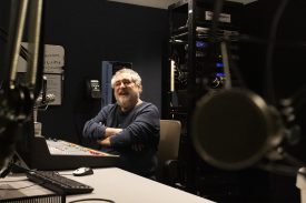 Man smiling in radio broadcasting room