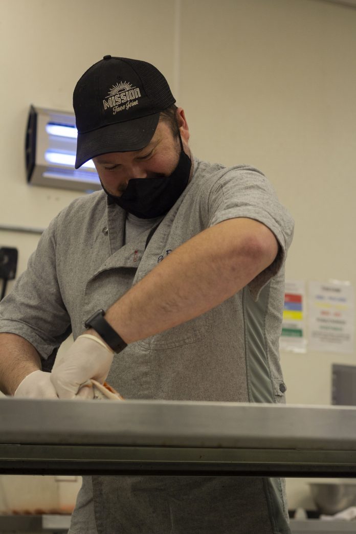 Man wearing mask and gloves cooking