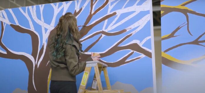 Muralist working on large tree design