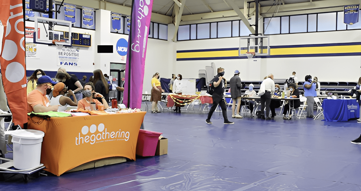 Indoor event with people and colorful booths.