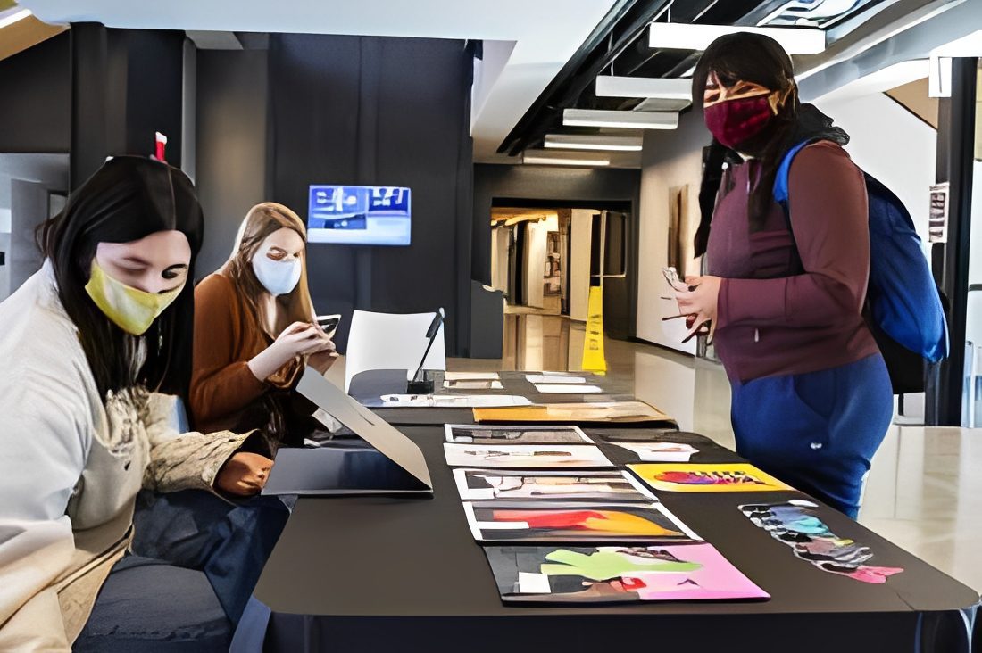 Group examining art pieces with masks on