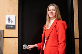 Smiling woman near restroom sign