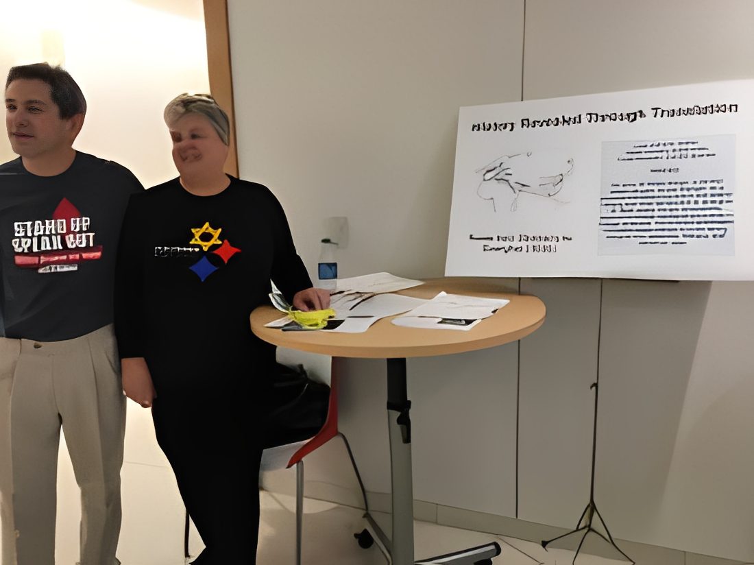 Two people standing by a presentation board