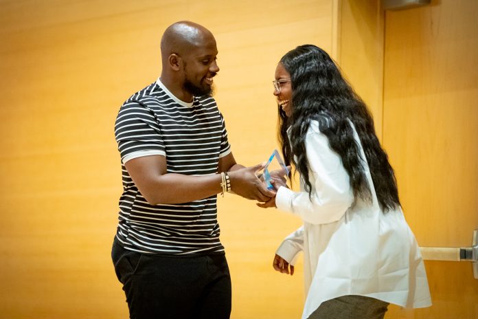 Man and woman exchanging an award