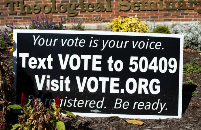 Register to vote sign with website link