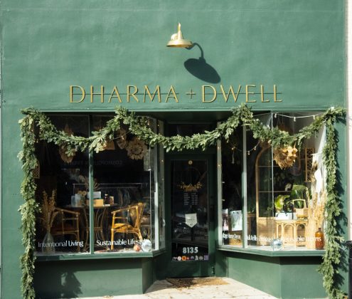 Green storefront with festive garland