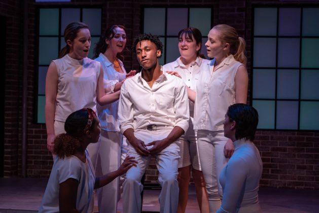 Diverse cast in dramatic stage scene