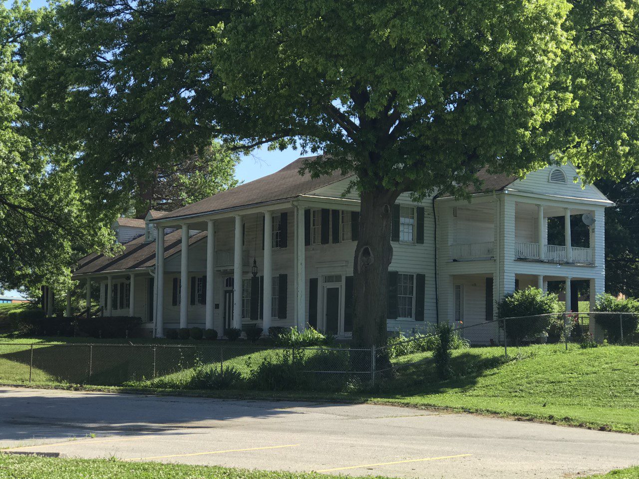 Two-story house with columns and greenery