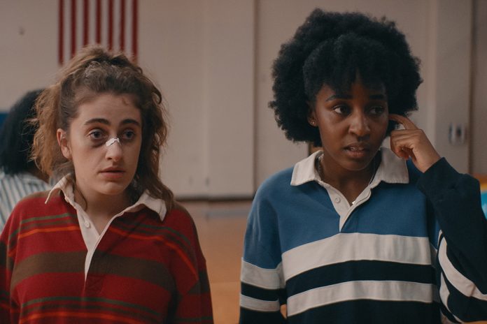 Two women in striped shirts indoors.