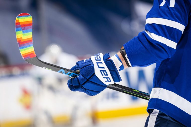 Blue hockey glove holding stick