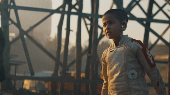 Young astronaut stands determinedly outdoors