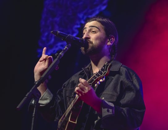 Musician performing on stage with guitar