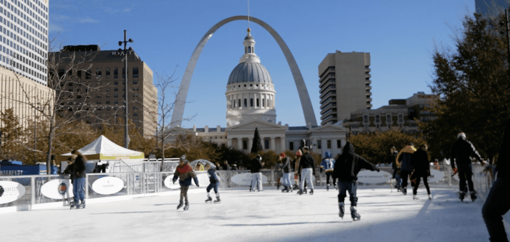 Ice rink bustling with skaters under clear sky