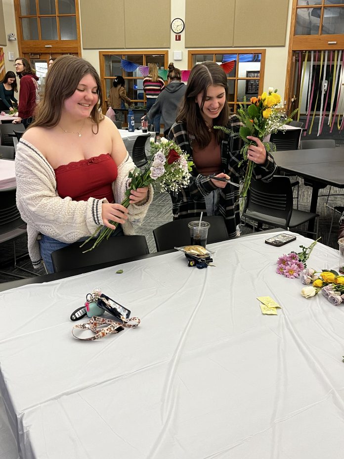People arranging flowers at a table