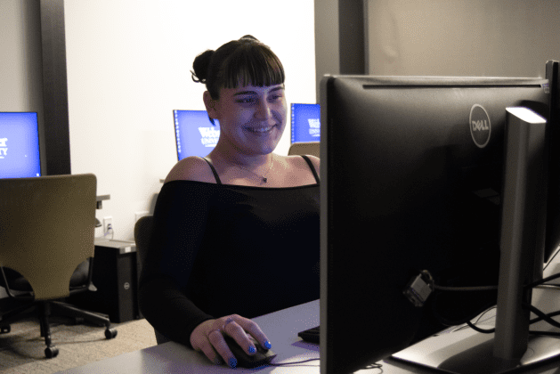 Woman smiling at computer screen