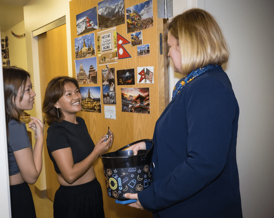 Women chatting by a decorated dorm door