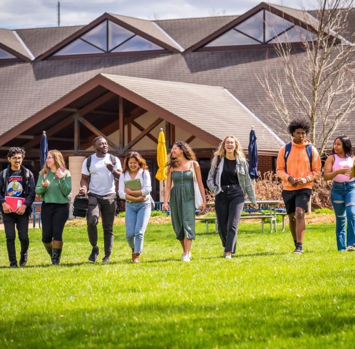 Diverse students walking on campus lawn