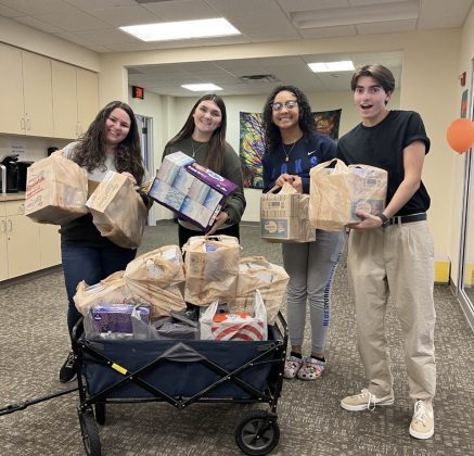 Four people with a wagon of groceries