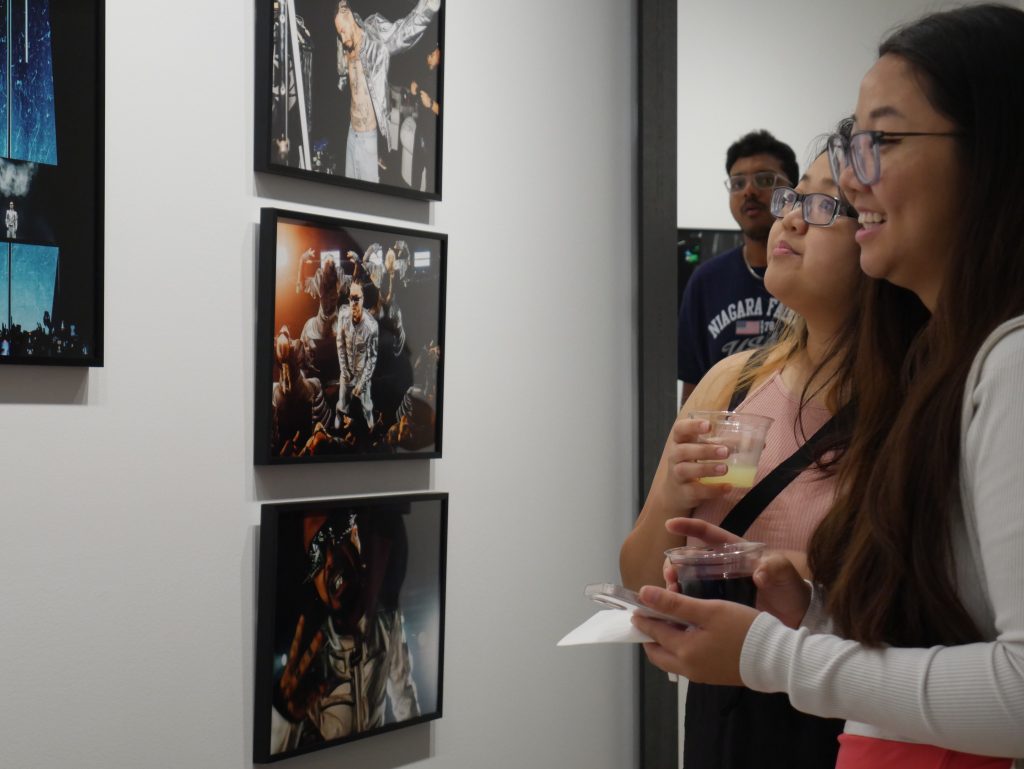 Two women admiring framed photographs