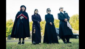People in black cloaks standing outside