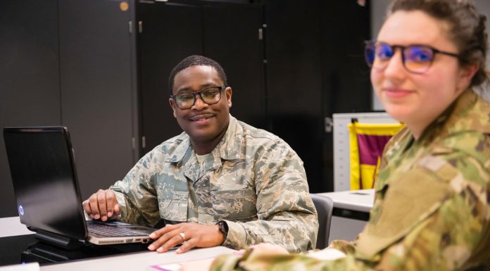 Military personnel working on laptops