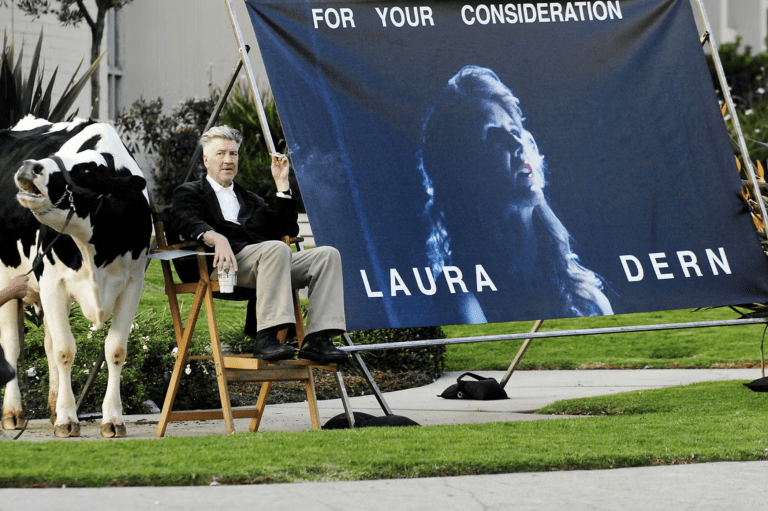 Director sitting by film advertisement