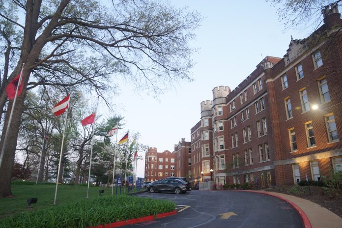 Historic building with flags and trees