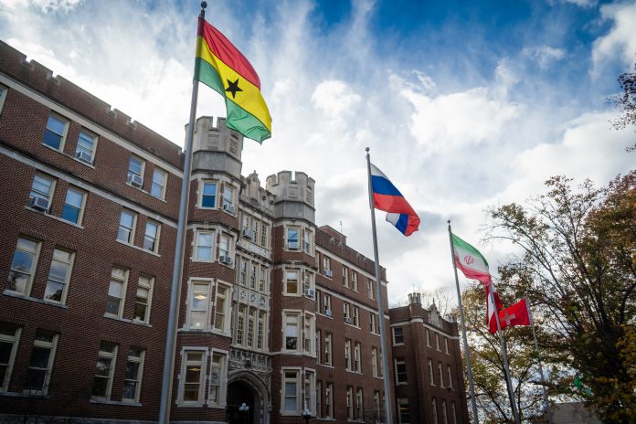 Cloudy sky over university campus flags
