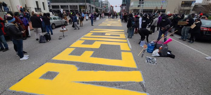 Protesters paint message on road