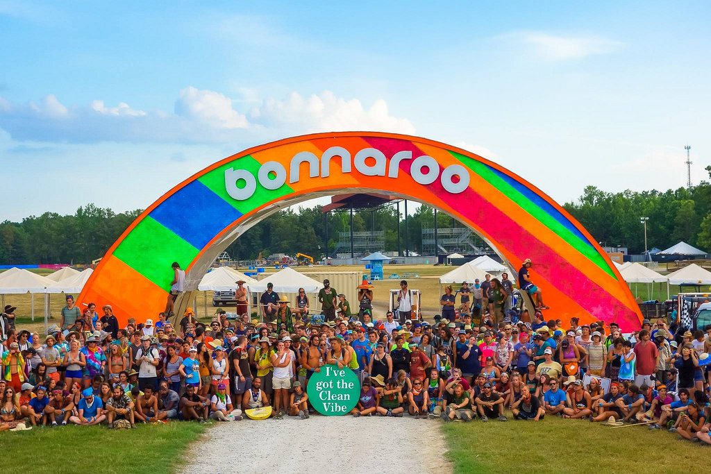 Festival crowd under colorful Bonnaroo arch