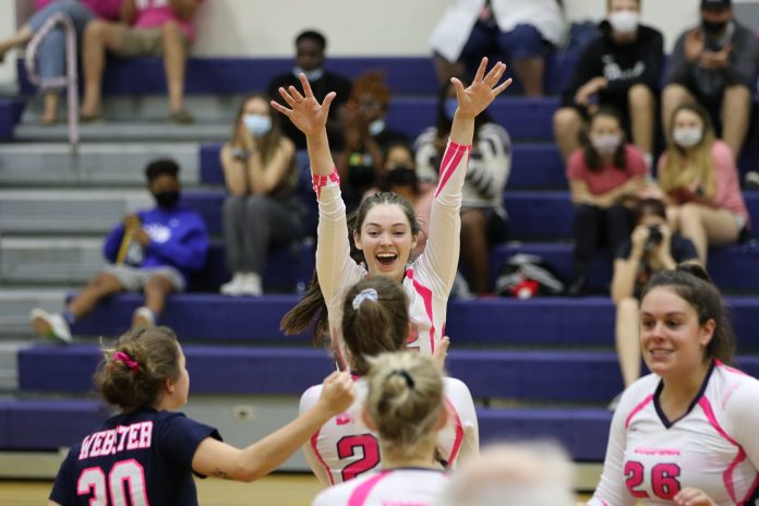 Players in pink jerseys celebrating victory