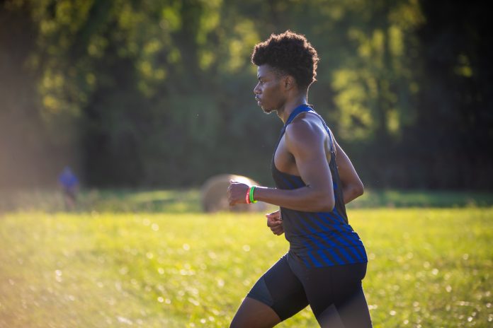 Athlete jogging outdoors in sunlight
