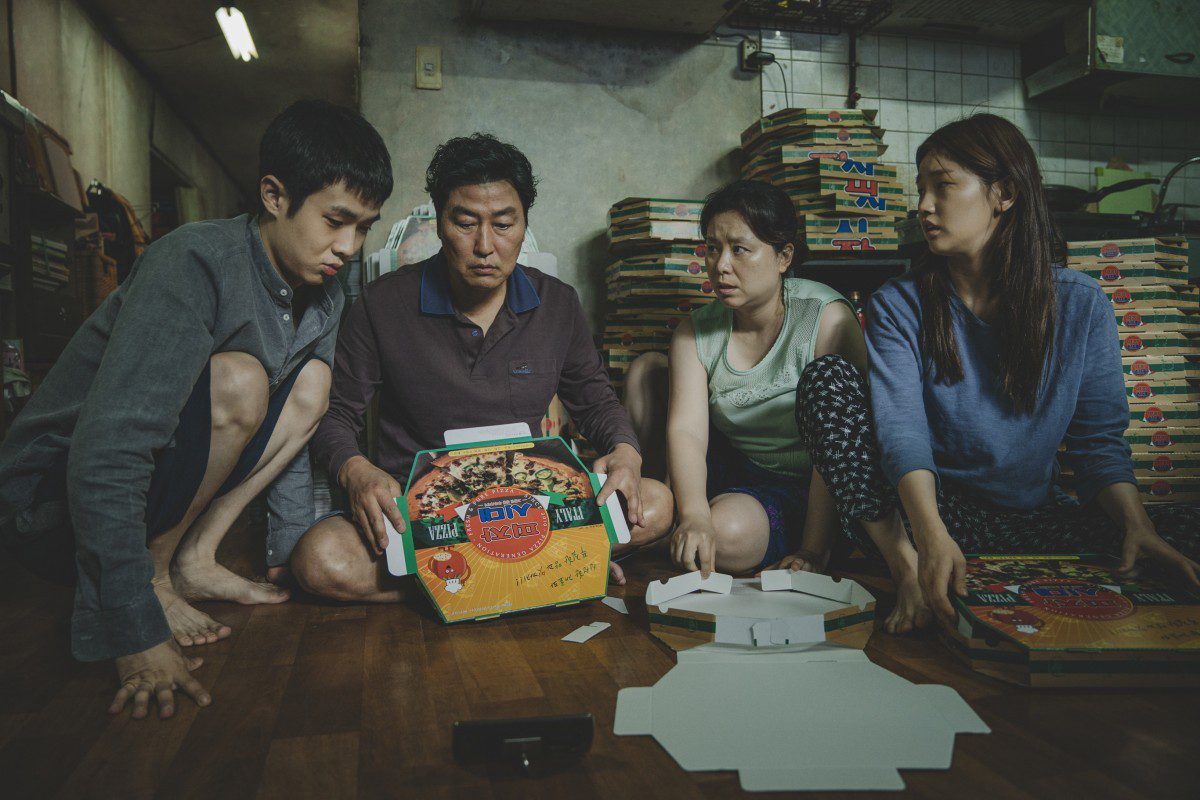 Four people focused on pizza boxes