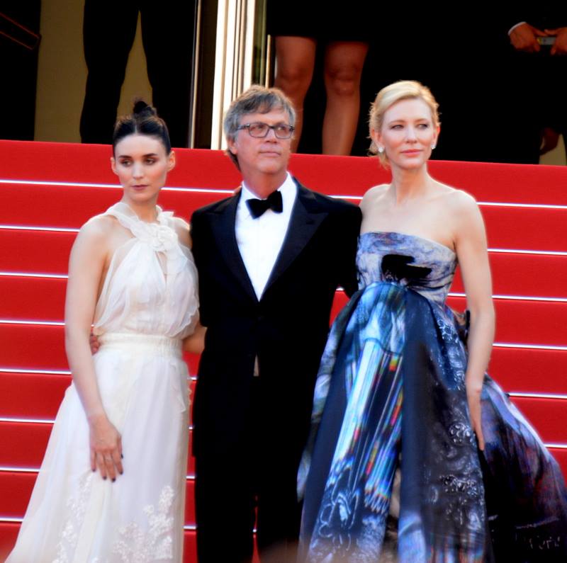 Three people posing on red carpet