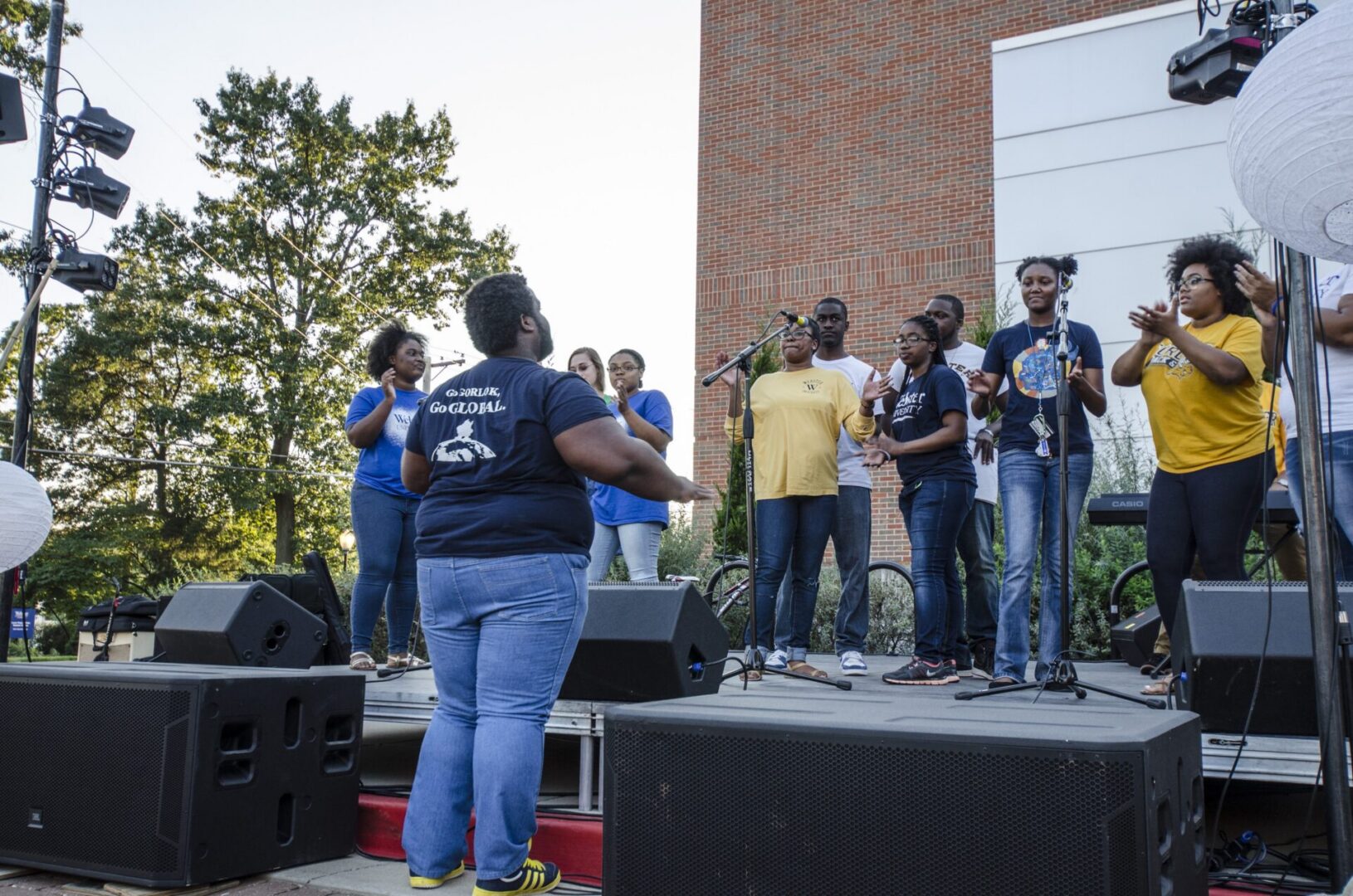 Group singing on stage outdoors