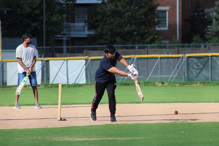 Cricket player batting on field