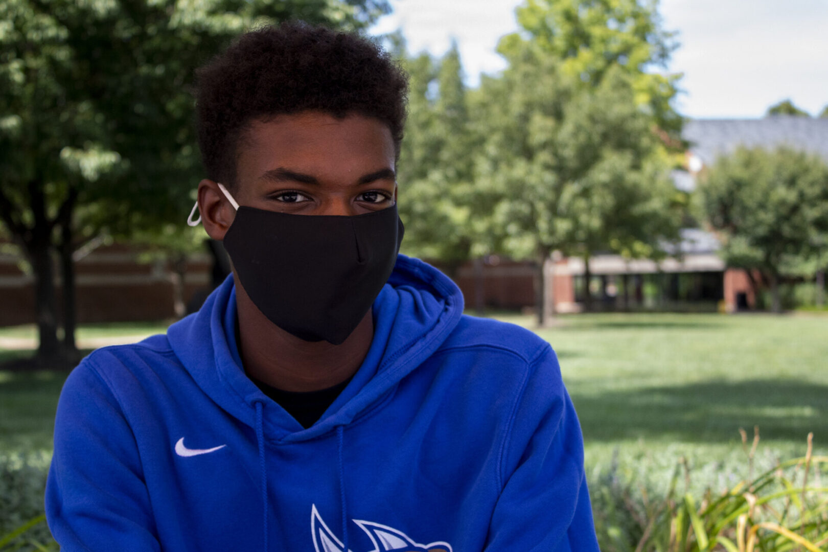 Masked person sitting in a park area