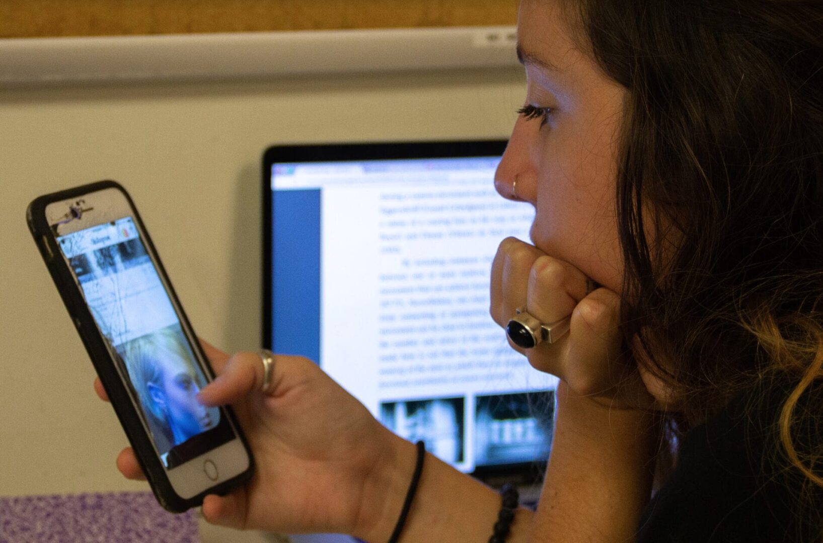 Woman multitasking with phone and laptop