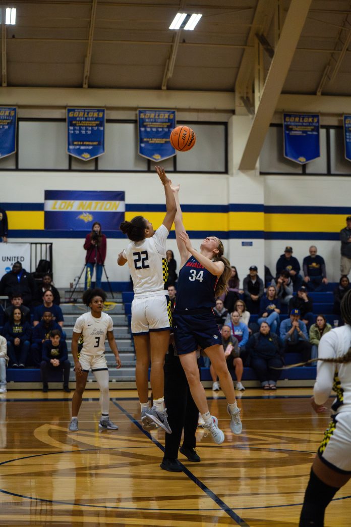 Players jump for basketball in game