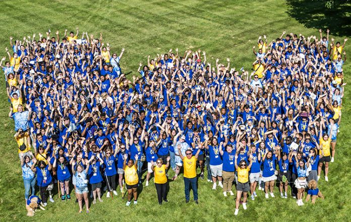 People in blue shirts forming "M" shape
