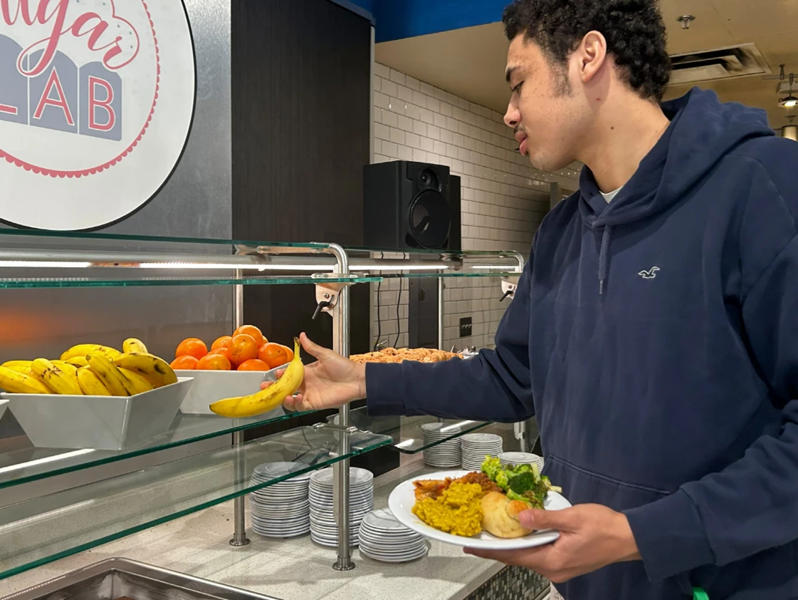 Individual holding plate at salad bar