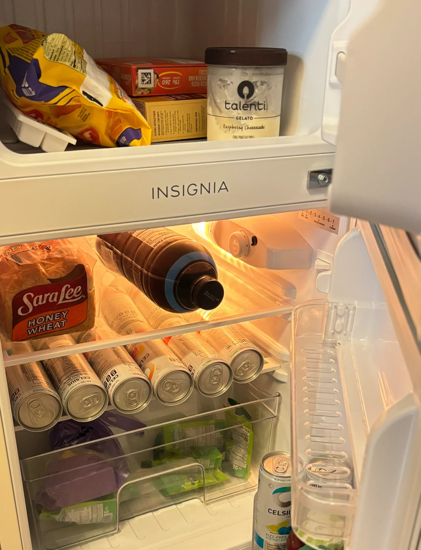 Open fridge with various food items inside