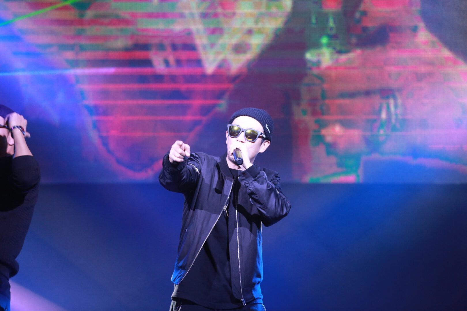 Artist in sunglasses pointing at audience