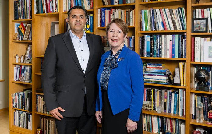 Colleagues posing by a book collection
