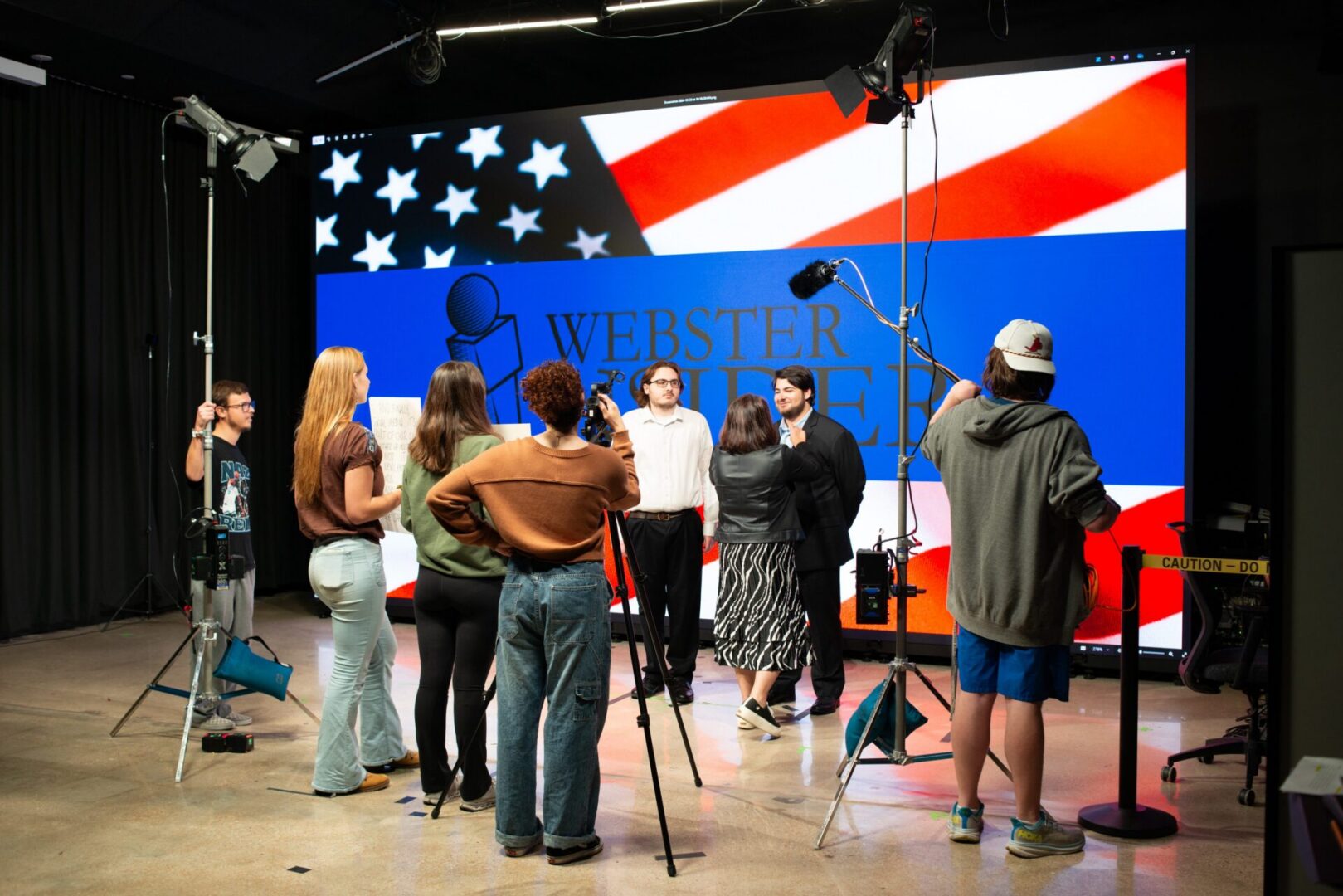 Film crew shooting in studio with American flag