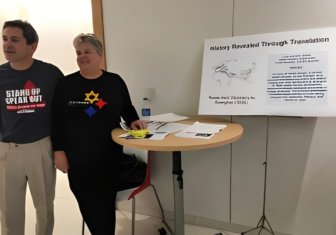 Two people standing by a presentation board